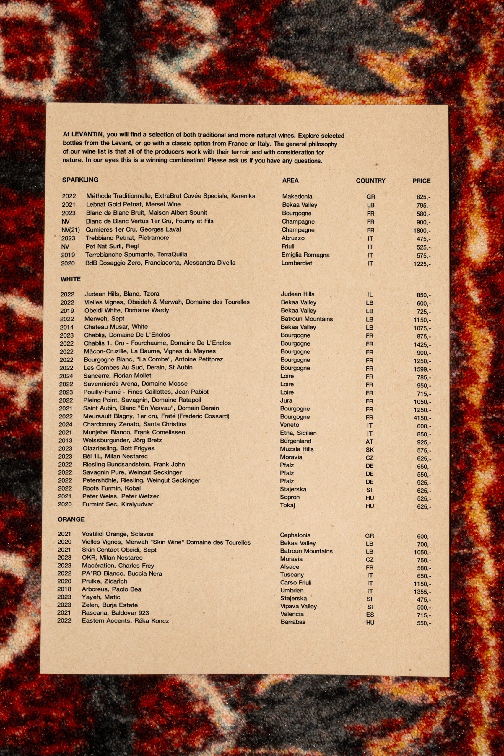 List of wines at Levantin, Middle Eastern bistro in Copenhagen. Brown paper placed on red, patterned carpet.